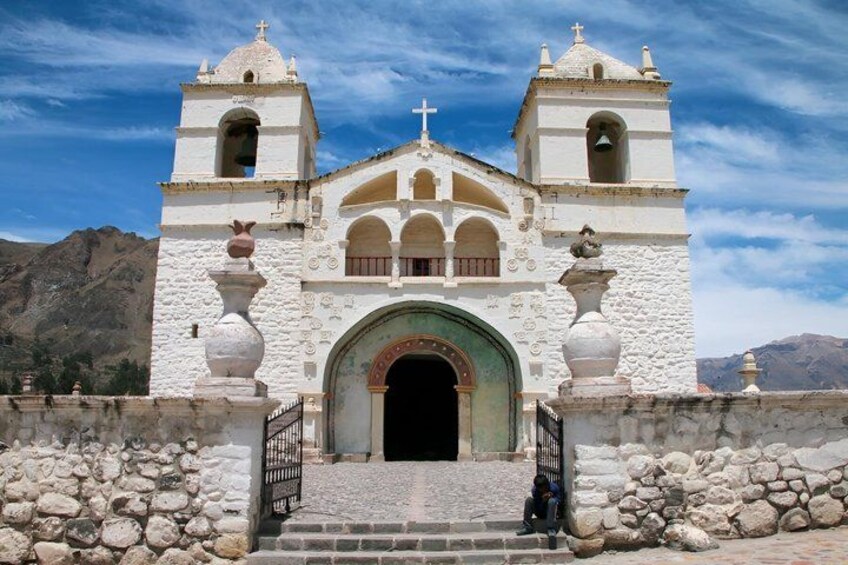 A white church with two bell towers and a central archway. 3