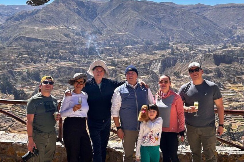 A group of people standing on a rocky outcrop with a mountainous landscape in the background. 2