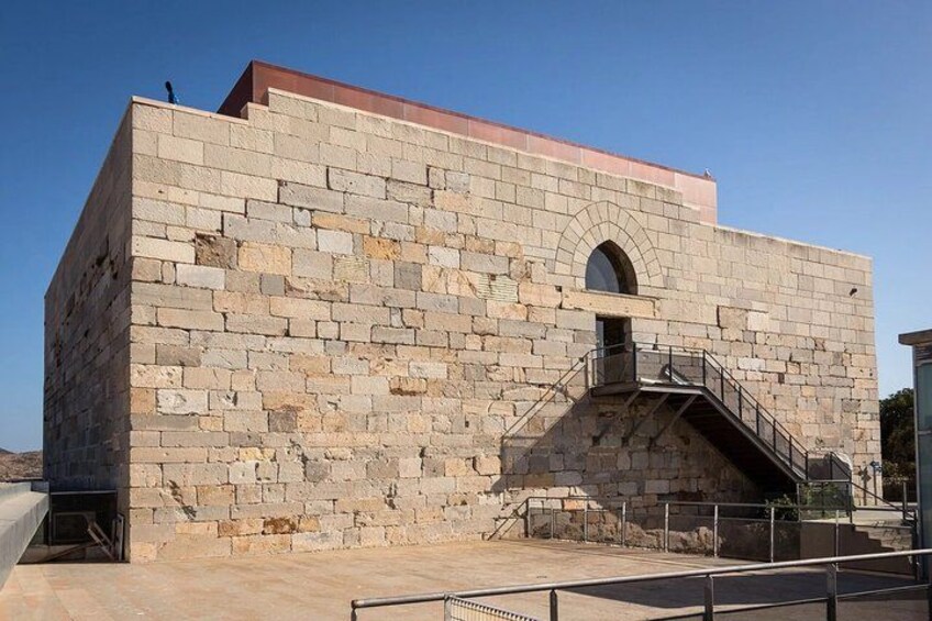 A stone building with a staircase and a small arched window. 2