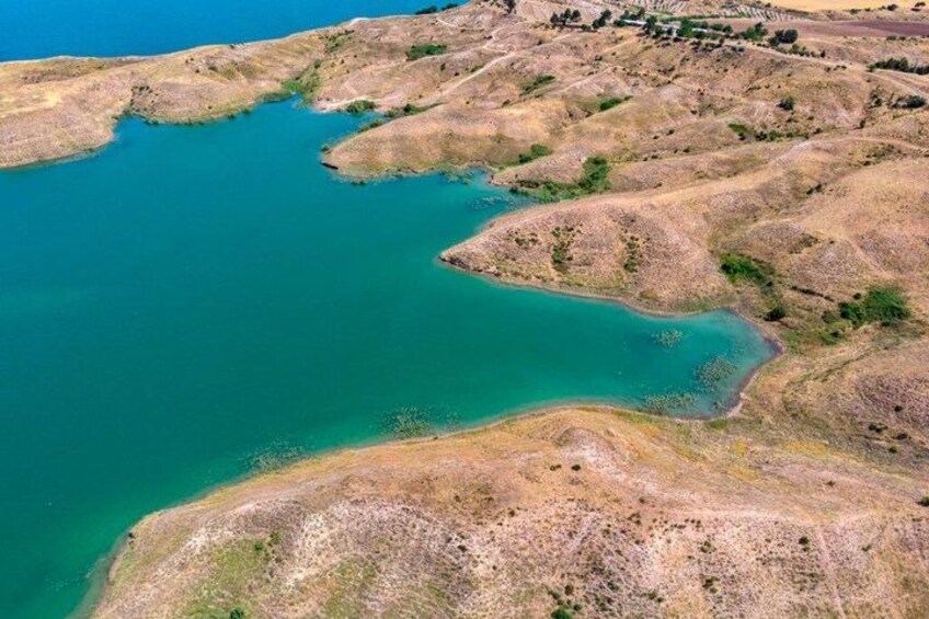 A large body of water surrounded by dry, hilly terrain. 2