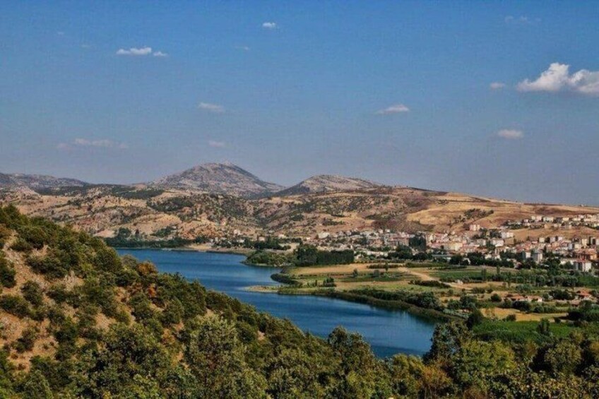 A river winding through a valley with hills in the background and a town on the right. 5