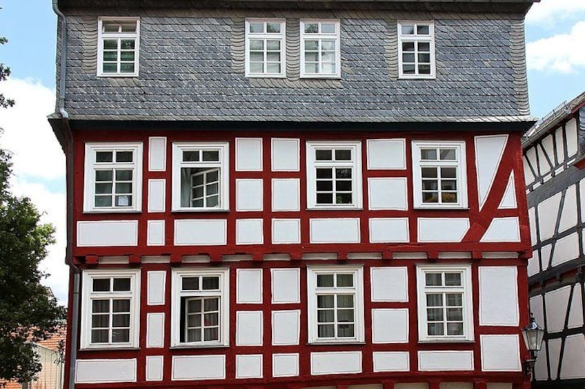 A half-timbered building with red and white panels and multiple windows. 5