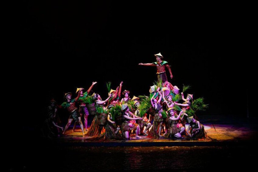 A group of performers in traditional costumes on a stage with a dark background. 4