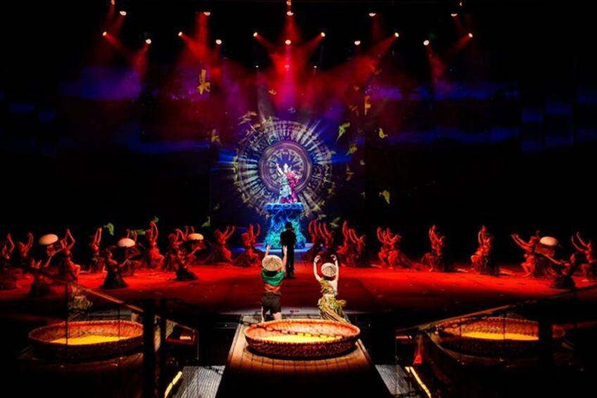A stage with performers, a large circular structure, and a central figure. 5