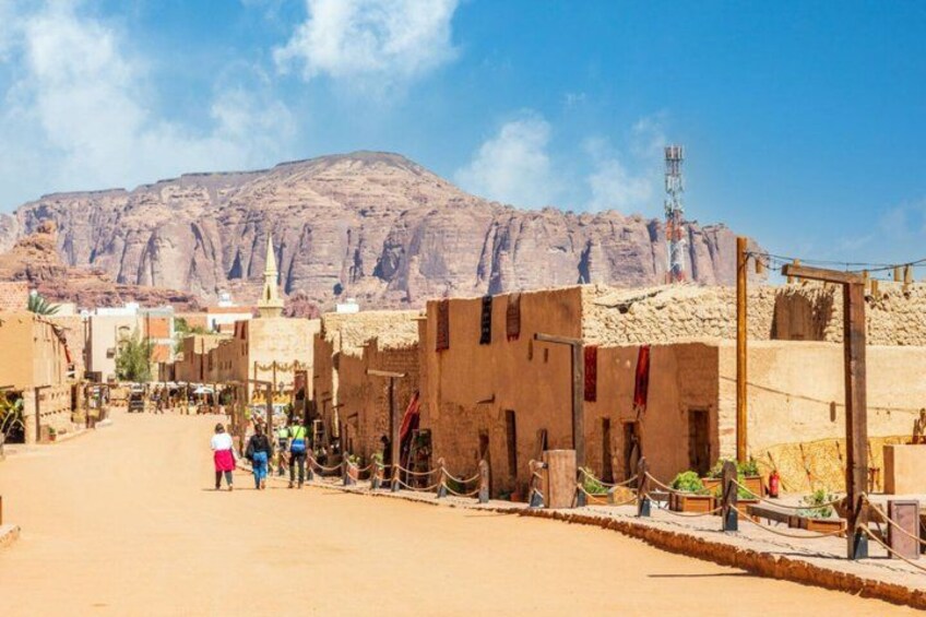 A desert town with buildings, a mountain in the background, and a clear sky. 5