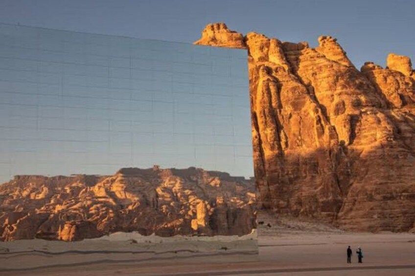A desert landscape with a prominent rock formation and a grid-like structure in the foreground. 5