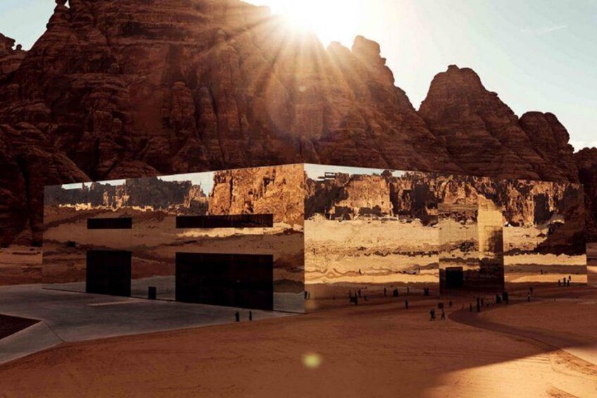 A desert landscape with rock formations and a large, modern structure. 2