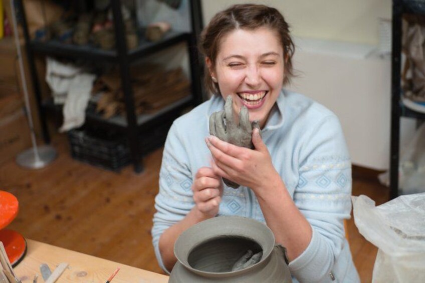 A person holding a clay pot. 1