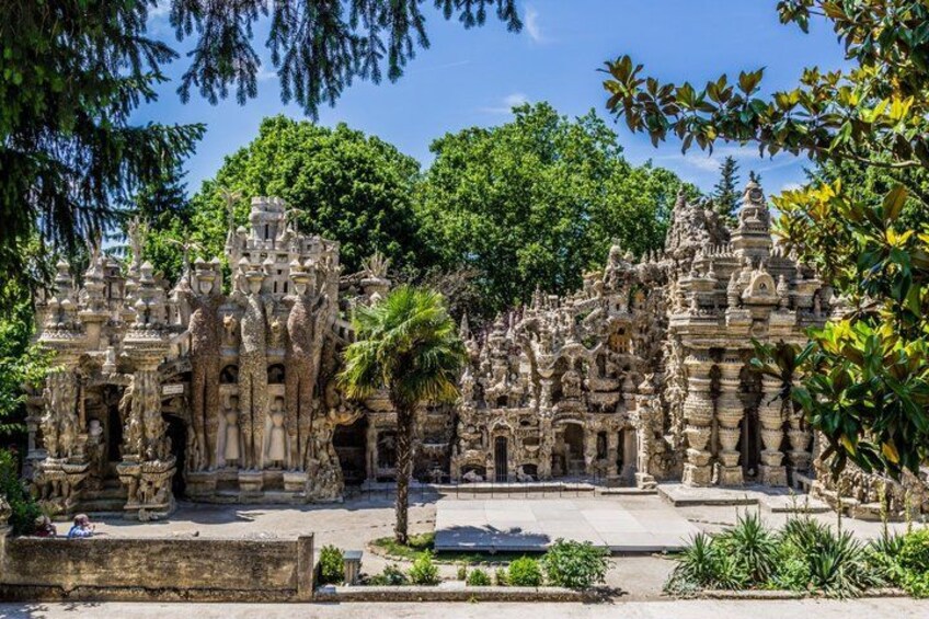 Ancient stone structures with intricate carvings, surrounded by lush greenery and trees. 2