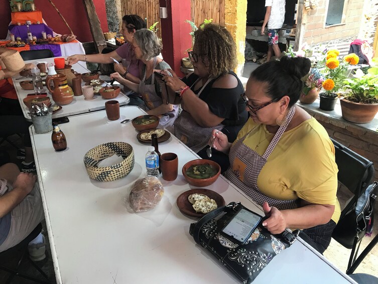 A group of people dining outdoors at a table with various dishes and drinks. 2