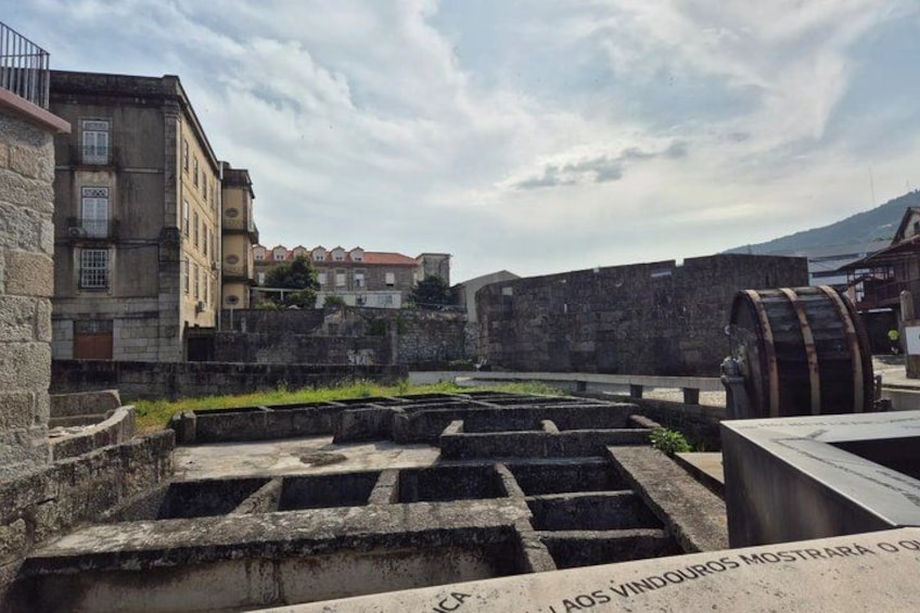 An old fort with stone walls, a large water wheel, and a building with balconies. 3