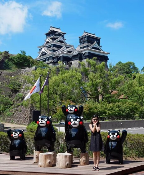 A person standing in front of a traditional Japanese castle with bear statues. 5