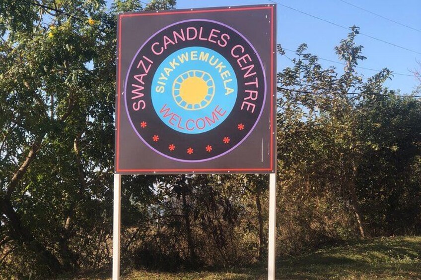 A sign for Swazi Candles Centre with a welcoming message. 3