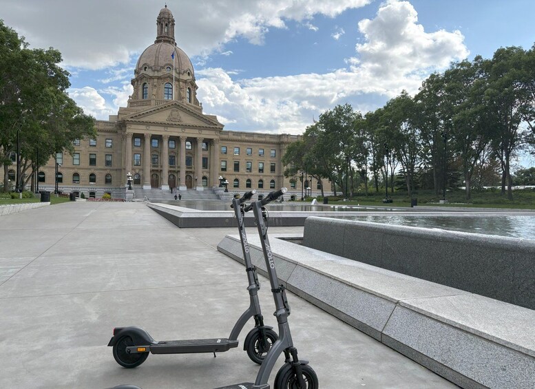A large building with a dome, a fountain, and two electric scooters in a plaza. 4