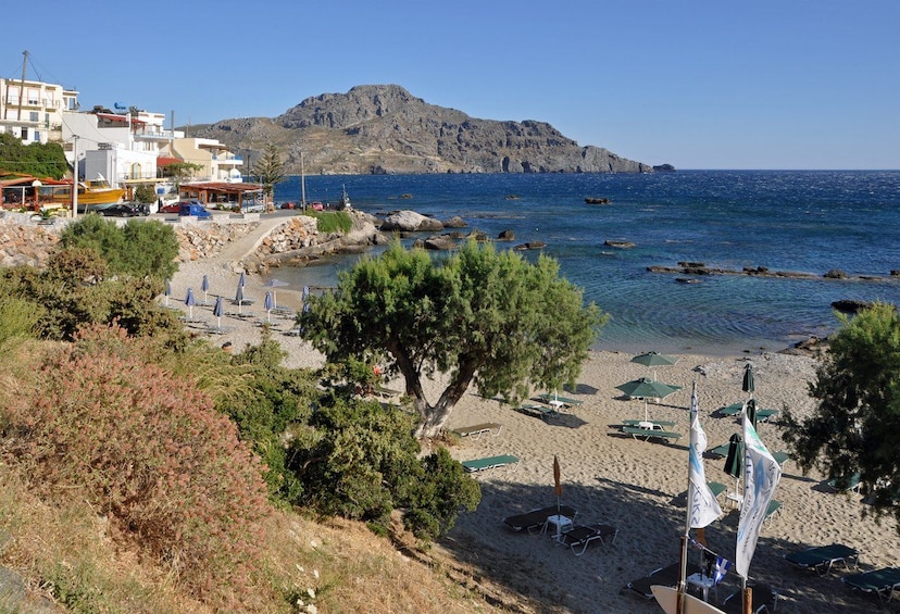 A coastal town with a beach, rocky outcrops, and a mountain in the background. 2
