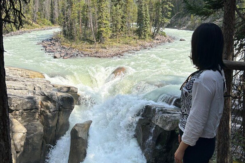 A person observing a river with a waterfall. 4