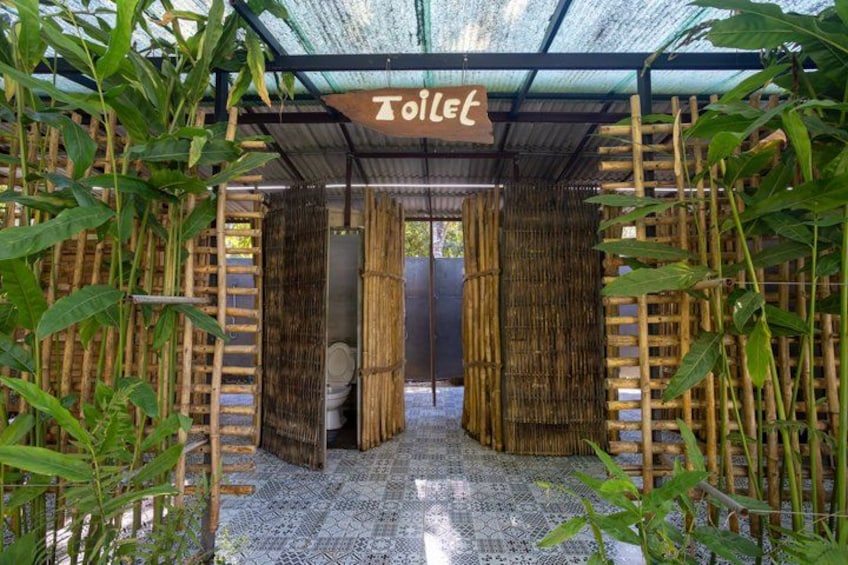 A bamboo structure with a toilet and a sign labeled 'Toilet.' 2