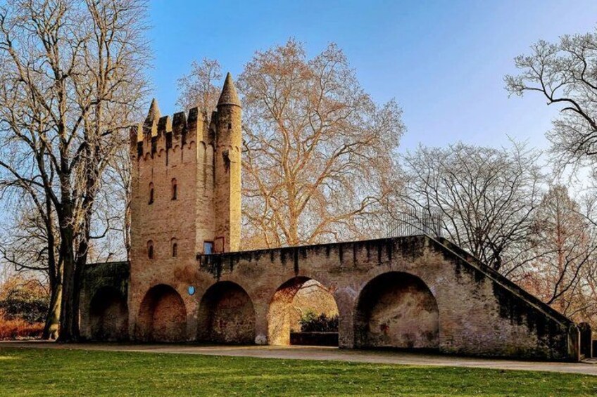 A medieval castle with a tall tower and a bridge with arches. 2