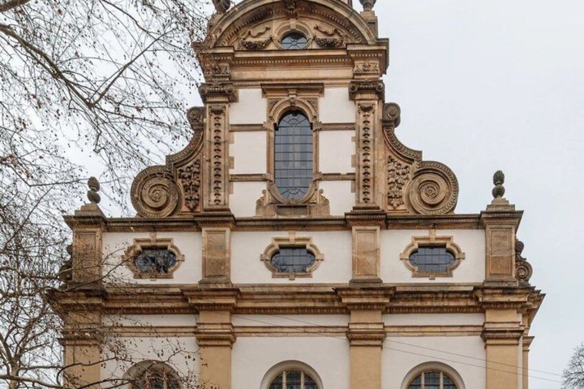 A building with ornate architectural details, including a central arched window and decorative elements. 4