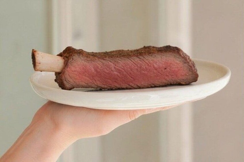 A cooked steak on a white plate. 2
