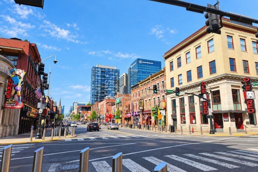 A city street with buildings, traffic lights, and a pedestrian crossing. 4