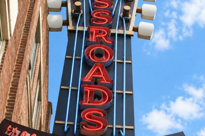 A sign for 'SROADS' with a clear blue sky in the background. 3