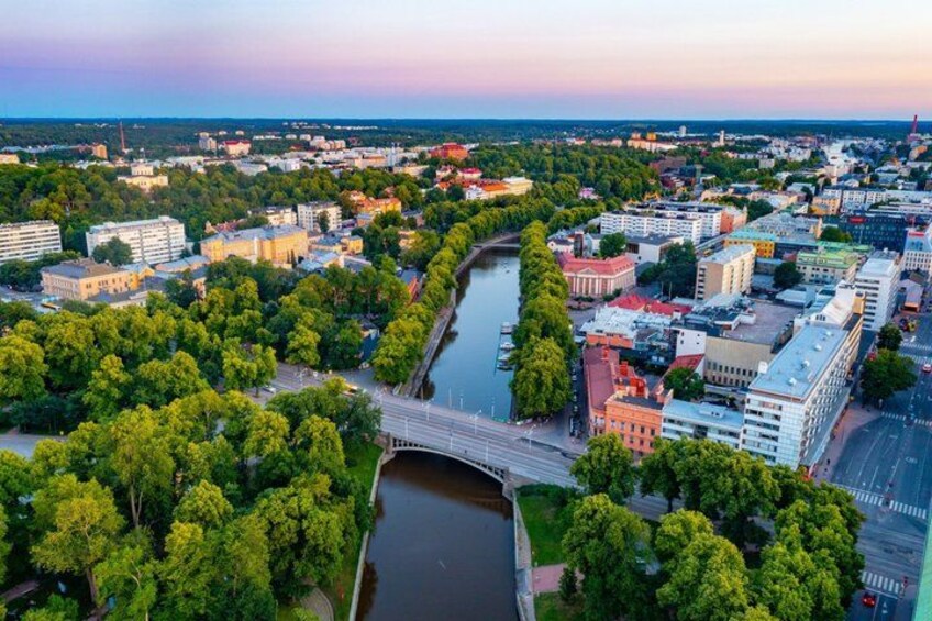 Un paisaje urbano con un río, un puente y zonas verdes circundantes. 3