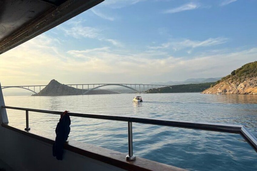 A boat on a river with a bridge in the background. 1