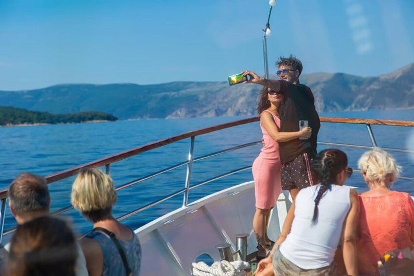 A boat with people on board, a clear blue sky, and a mountainous landscape in the background. 3