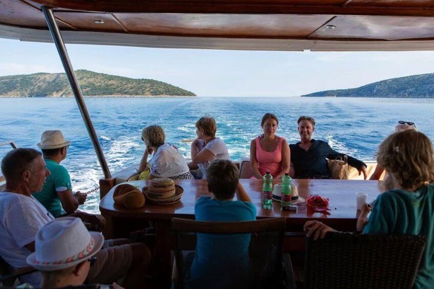 A group of people on a boat with a view of the sea and distant land. 5