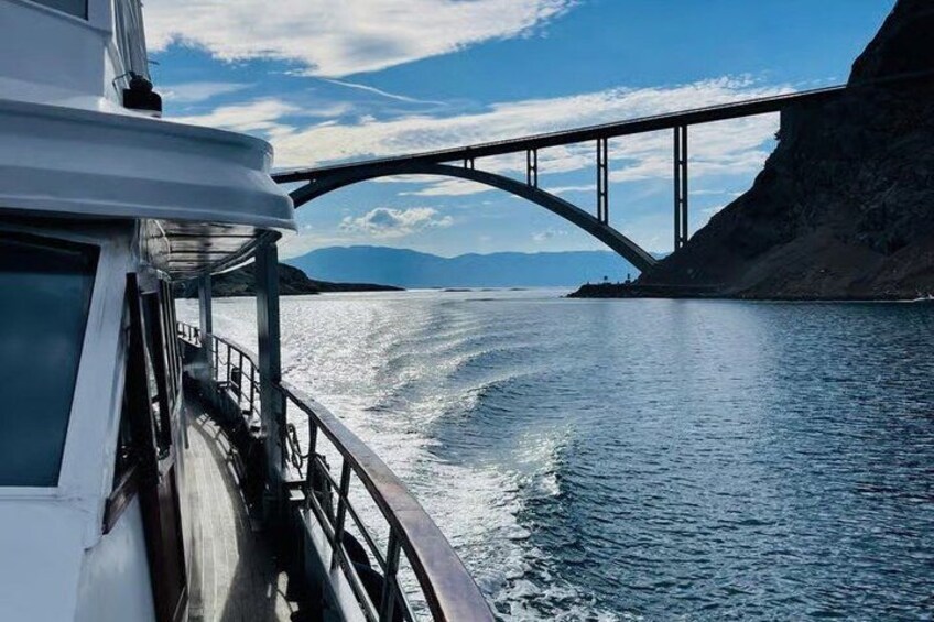A boat on water with a bridge in the background. 3