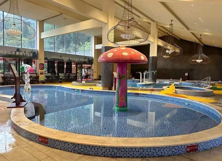 Une piscine intérieure décorée de champignons aux couleurs vives, entourée d’un sol carrelé et illuminée par des lampes suspendues. 3