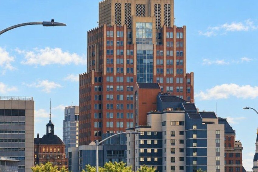 A cityscape with a prominent red and blue building, a street lamp, and a clear blue sky. 5