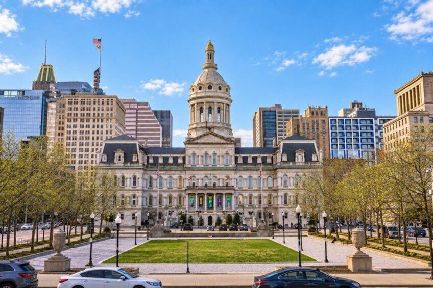 A large historic building with a dome, surrounded by modern skyscrapers and a well-maintained lawn. 1