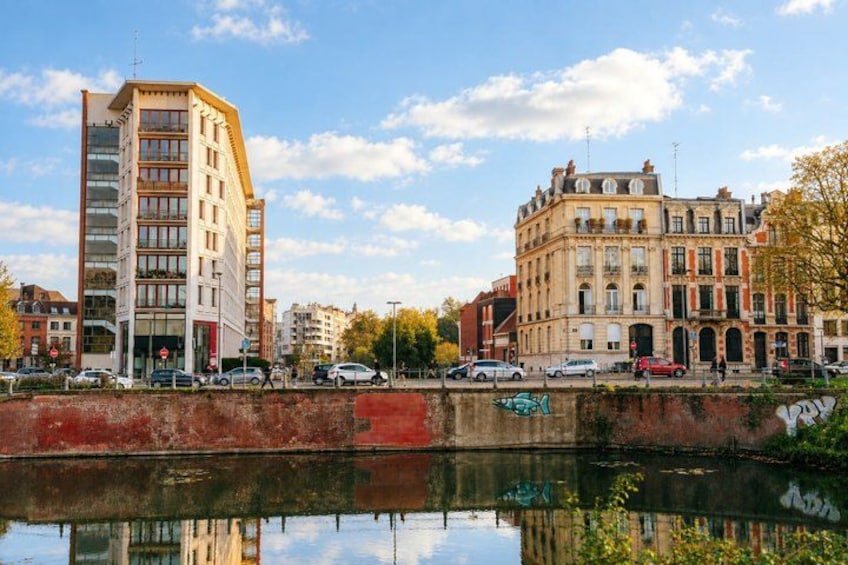 A river with buildings on the opposite bank, a bridge, and a clear sky. 4