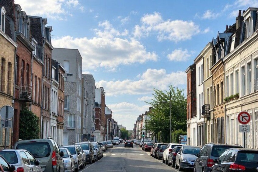 A street lined with parked cars and buildings. 5