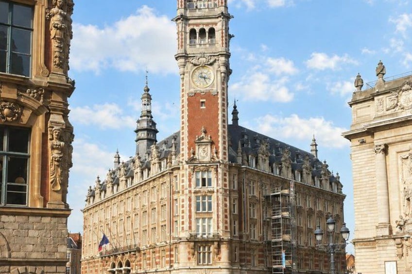 A historic building with a clock tower, ornate architectural details, and a clear sky. 3