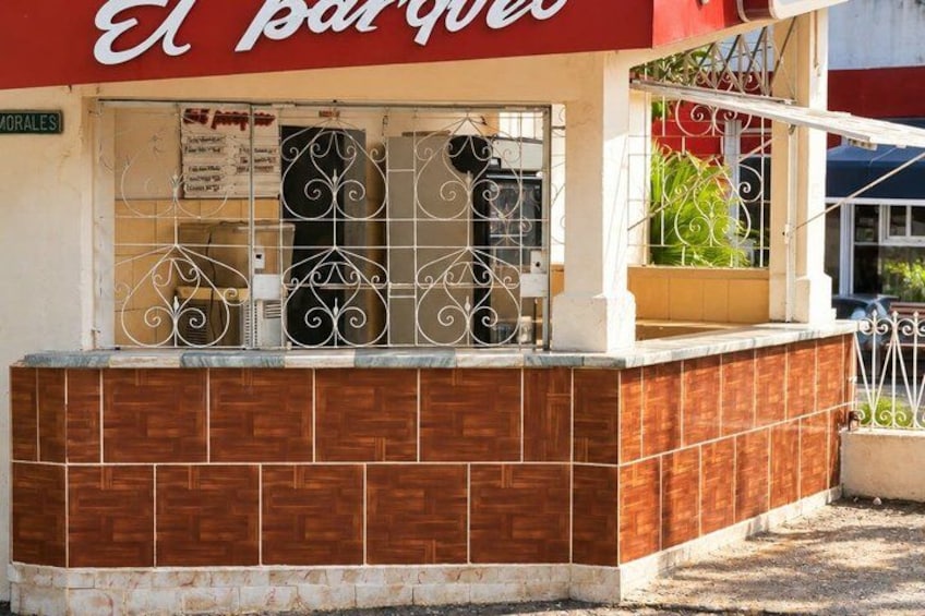 A building with a red awning and a sign that reads 'El Barquito'. 5