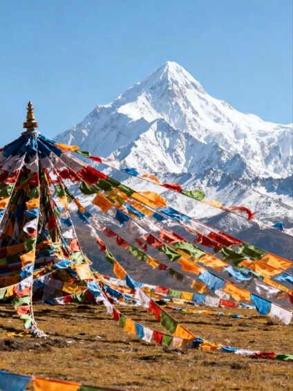 A snow-covered mountain with colorful prayer flags in the foreground. 2