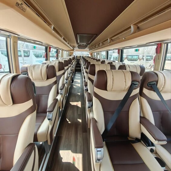 A bus interior with rows of seats, windows, and overhead compartments. 4