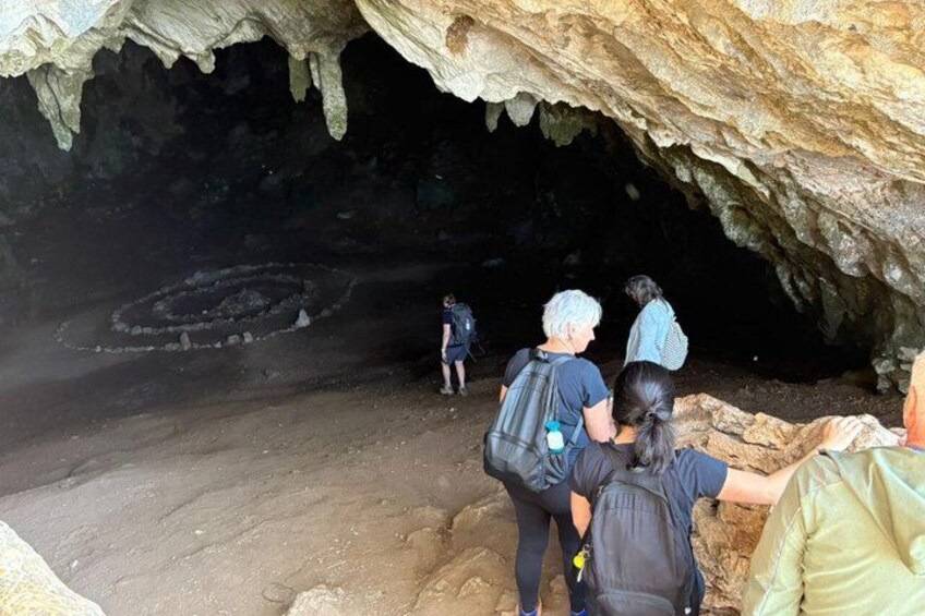 A group of people exploring a cave with stalactites. 2