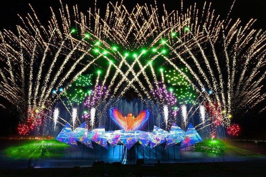 A nighttime fireworks display with a central stage and colorful lights. 2