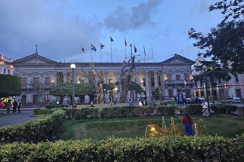 A classical building with columns, flags, and a well-maintained garden. 5