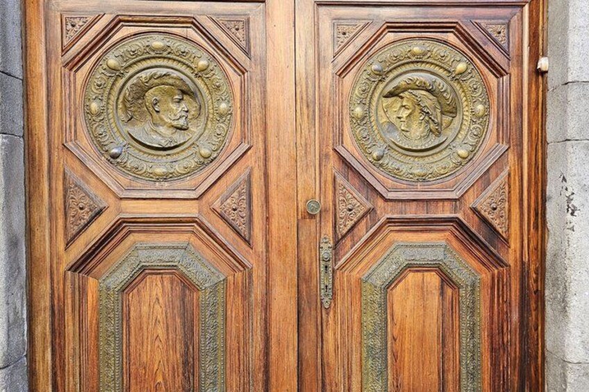 A wooden door with intricate carvings and brass details. 5