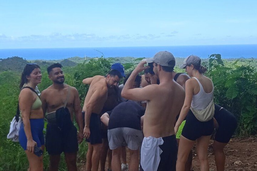 A group of people standing on a hill overlooking a coastal landscape. 1