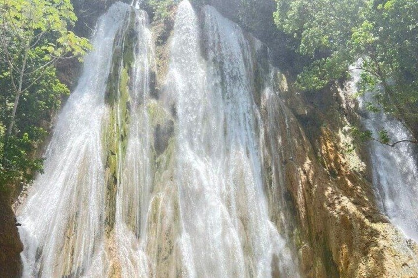 A waterfall cascading down a rocky cliff surrounded by greenery. 5