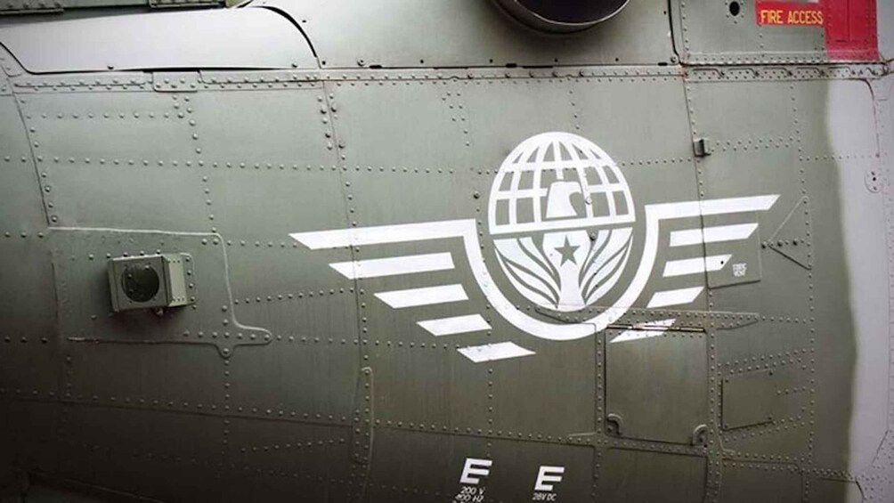 A military aircraft with a globe and wings logo, rivets, and a fire access sign. 4