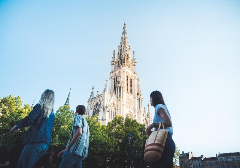 A group of people walking towards a large, ornate cathedral with intricate spires and detailed architecture. 3
