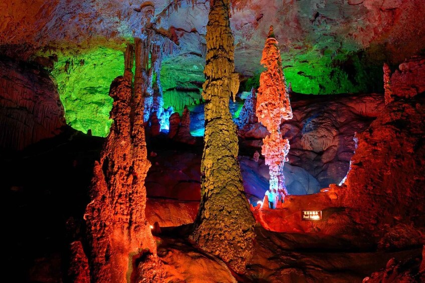 Une grotte ornée de stalactites et de stalagmites, illuminée de lumières colorées. 5