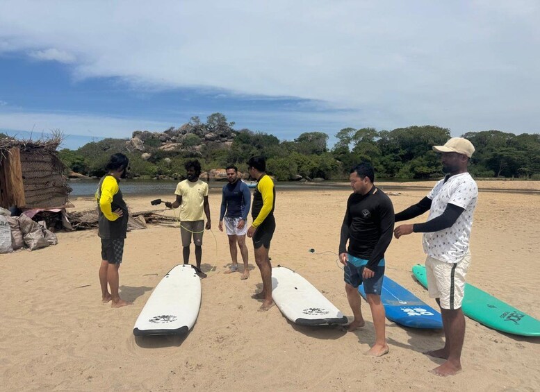 Eine Gruppe von Menschen am Strand mit Surfbrettern. 3